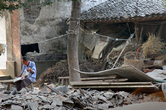 Old Man Reading Newspaper amid Rubble